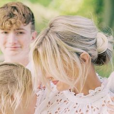 a woman and two children are looking at something