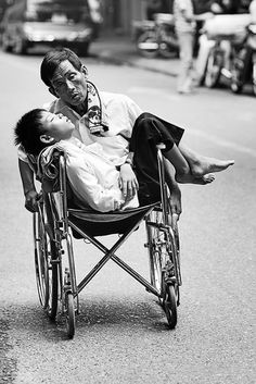 a man in a wheel chair holding a baby