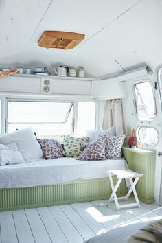 a white couch sitting inside of a living room next to a window with lots of windows