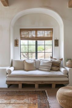 a white couch sitting under a window in a living room