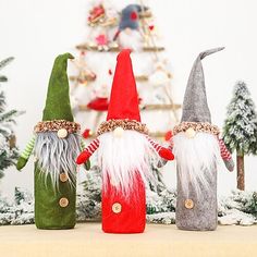 three gnomes are standing next to each other in front of a christmas tree,