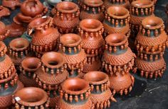 many brown vases are stacked on top of each other and placed in the same pattern