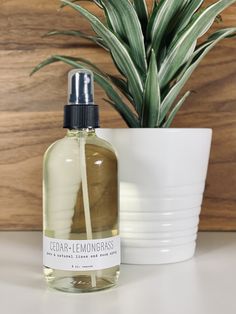 a bottle of cedar - lemongrass cologne next to a potted plant