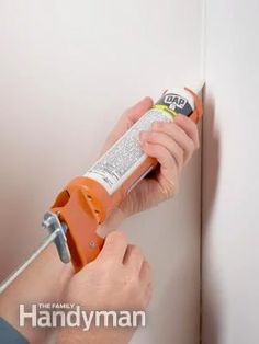 a person using a screwdriver to fix a wall