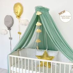 a baby crib with gold stars and balloons hanging from it's canopy over the crib