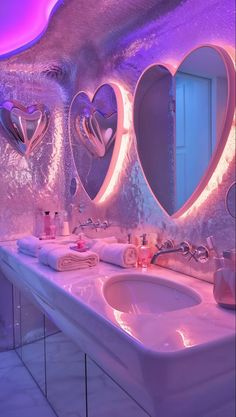 a bathroom with two sinks and mirrors in the shape of heart shaped lights on the wall