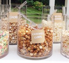 several glass containers filled with different types of popcorn