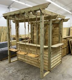 a wooden swing set in the middle of a room