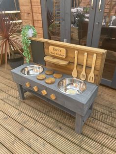 an outdoor kitchen made out of wood and metal bowls, spoons and spatulas