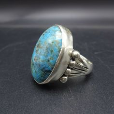 "PAUL LIVINGSTON NAVAJO BLUE MOON TURQUIOSE RING DESCRIPTION: This ring features a glorious specimen of Blue Moon turquoise. The gemstone is secure in smooth bezel, on a foundation of heavy gauge sterling silver. The substantial split-shank band is punctuated with applied raindrops. This ring will be a treasured addition to your collection of fine Native American jewelry. MEASUREMENTS: Ring face measures 1\" x 3/4\" Cabochon measures 25mm x 18mm RING SIZE: 8 1/4 WEIGHT: 12. grams SIGNED: Paul Li Vintage Turquoise Ring With Large Oval Stone, Vintage Oval Turquoise Ring With Large Stone, Antique Handmade Blue Turquoise Ring, Vintage Blue Turquoise Cabochon Ring, Vintage Blue Cabochon Turquoise Ring, Antique Handmade Turquoise Blue Ring, Handmade Antique Blue Turquoise Ring, Handmade Antique Turquoise Ring, Blue Sterling Silver Ring With Patina