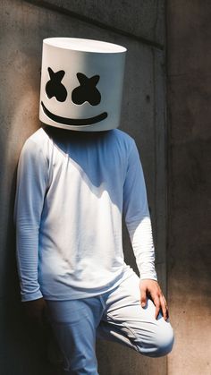 a person wearing a white shirt and hat with eyes painted on it's face