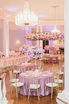 the tables are set up with pink flowers and chandeliers in the centerpieces