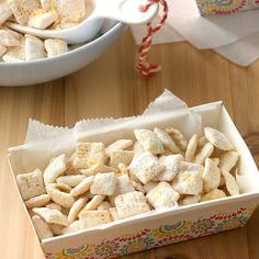 a box filled with marshmallows sitting on top of a table next to a bowl of candy canes