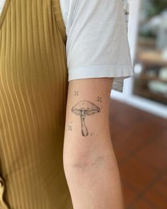 a person with a mushroom tattoo on their arm