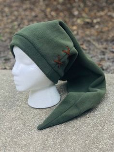 a white mannequin head wearing a green hat with red crosses on the side