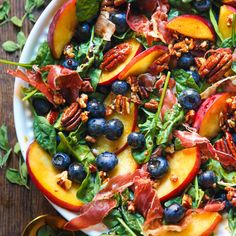 a salad with peaches, blueberries and pecans