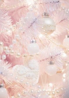 a pink christmas tree with ornaments and pearls on it's branches in pastel tones