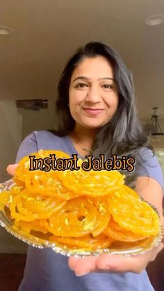 a woman holding a plate full of sliced oranges in front of her face and the words instant jalebs above it