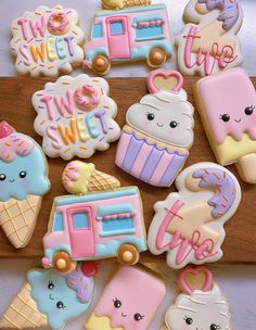 some decorated cookies are sitting on a cutting board with the words sweet and ice cream