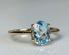 Lovely vintage genuine Aquamarine engagement ring with stunning natural earth mined Aquamarine in 14k gold. The Aquamarine is a beautiful tropical water blue with aqua green hue and is estimated to weigh 1.75 carats (~9 mm x 7 mm). The stone is an older oval cut with a smaller high table and appears to be unheated (rare!). Inside of the ring is stamped for 14k gold. Details: Ring is stamped for 14K.  Ring weighs 2.8 grams.  Currently a size 6.5 and can be sized by adding our custom sizing listin Cushion Cut Aquamarine Engagement Ring, Aquamarine And Sapphire Engagement Ring, Aquamarine And Gold Ring, Gold Aquamarine Engagement Ring, Aquamarine Oval Ring, Classic Aquamarine Birthstone Ring, Yellow Gold Aquamarine Rings For Anniversary, Heirloom Aquamarine Rings For Gifts, Classic Aquamarine Ring As A Gift