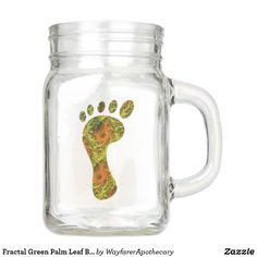 a glass jar with a hand and foot print on the inside, sitting in front of a white background