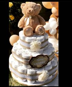 a teddy bear sitting on top of a diaper cake