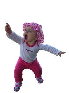 a small child wearing a pink hat and holding her arms out