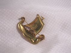 Rare Coro c1940's Gold Plated Sterling, Enameled Viking Ship Brooch Beautiful vintage brooch, hand enameled over gold plated sterling. The brooch is 2 inches long in good condition. There is very small scratch in the enamel on the bottom of the sail near the mast pole. Collectible Gold Enamel Pins, Yellow Gold Enamel Pin Collectible, Antique Gold Enamel Brooches, Vintage Yellow Gold Enamel Pin Collectible, Vintage Yellow Gold Enamel Pin For Collectors, Vintage Gold Enamel Brooches, Vintage Yellow Gold Enamel Pin, Viking Ship, Vintage Brooch