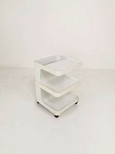 two tiered white plastic cart with wheels on the bottom and one shelf is empty