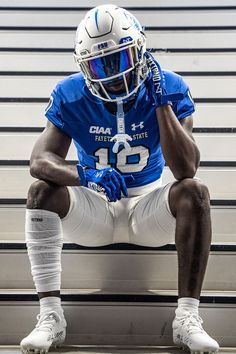 a football player is sitting on the bleachers with his foot in his hand