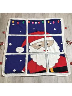 a knitted santa clause is shown on the floor in front of a window with christmas lights