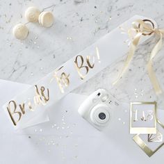 the bride to be sash is next to some confetti and gold decorations on a marble surface