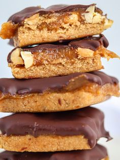 three cookies stacked on top of each other with chocolate frosting and nuts in the middle