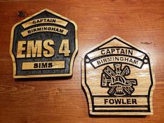 two wooden coasters with the words ems 4 and fowler on them are sitting next to each other