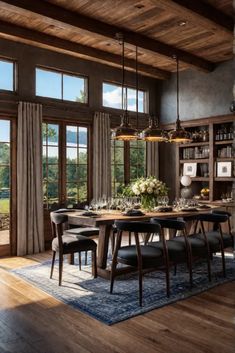 the dining room table is surrounded by black leather chairs and an area rug that matches the wooden ceiling