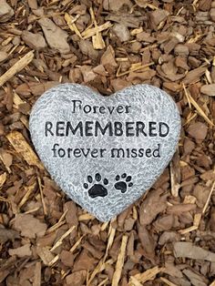 a memorial stone with a dog's paw on it that says, forever remembers forever missed