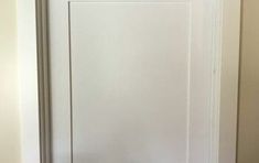 a white door with the handle on it in a home hallway or entryway area