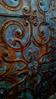 an intricately designed metal door is shown in this image, it appears to be rusted