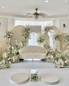 a white couch sitting next to a table with flowers on it