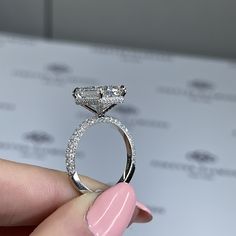 a person holding a diamond ring in their hand