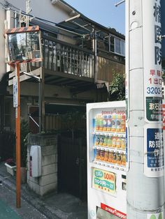 a vending machine sitting on the side of a road next to a tall building