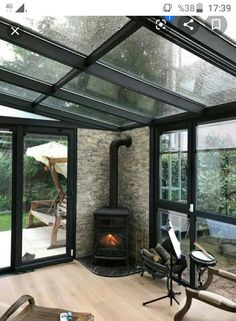 an image of a living room setting with wood burning stove in the center and large windows