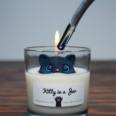 a candle with a cat face on it and a pen sticking out of the top