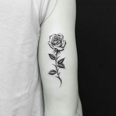 a black and white rose tattoo on the arm