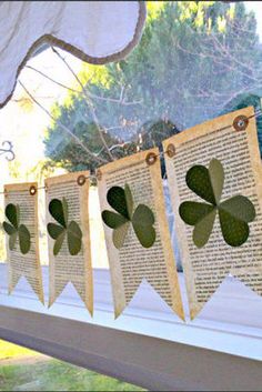 some paper shamrocks are hanging from a window sill