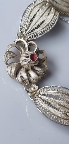 Not stamped but tests as 925 silver. A fine quality vintage filigree bracelet. Swirled raised flowers,  detailed with a small genuine Ruby in each centre. Interspersed with a raised leaf between each flower. A complete quality vintage piece, and not your run of the mill filigree. Push in type clasp and safety chain present. Excellent condition. Length is 20cm Width is 2.1cm Ornate Sterling Silver Bracelet, Ornate Sterling Silver Filigree Bracelet, Ornate Filigree Jewelry, Vintage Filigree Bracelets As Gift, Elegant Filigree Sterling Silver Bracelet, Vintage Sterling Silver Bracelet With Intricate Design As Gift, Elegant Sterling Silver Filigree Bracelet For Gifts, Vintage Sterling Silver Bracelet With Intricate Design For Gift, Gift Sterling Silver Bracelet With Intricate Design Vintage Style