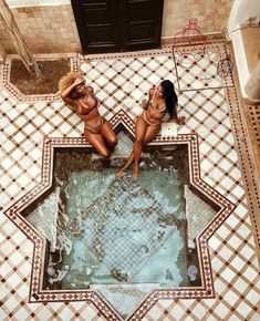 two women in bikinis are sitting on the floor