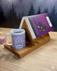 a cup of coffee sitting on top of a wooden table next to a book holder