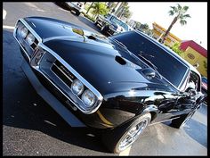 a black muscle car parked on the street