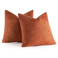 two orange pillows sitting next to each other